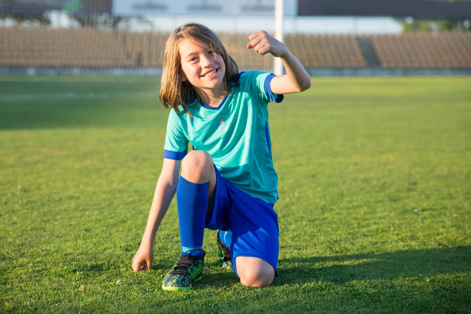 A young soccer player joyfully celebrates on the field, expressing excitement and achievement.
